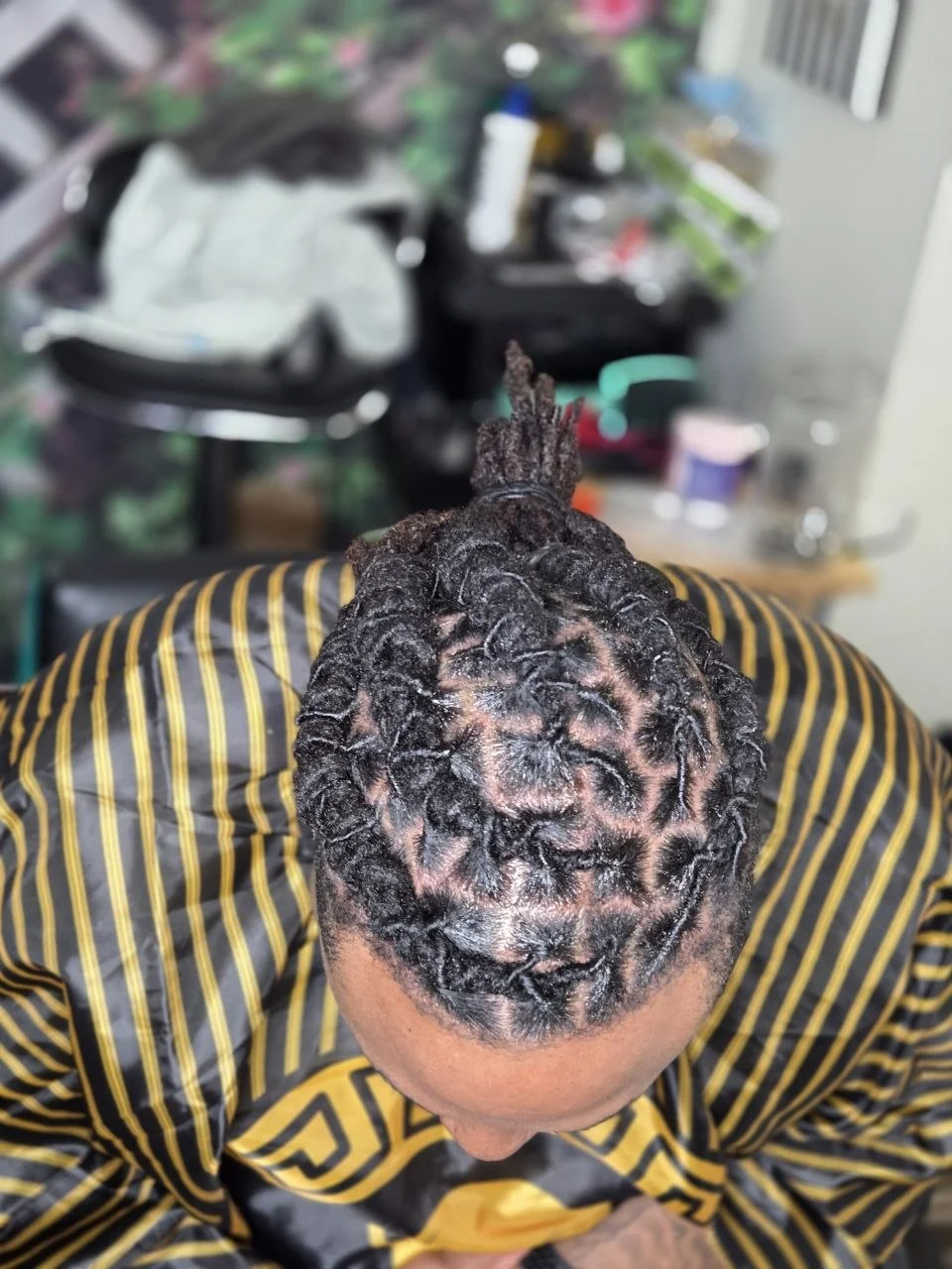 Top-down view of a client's head with small, tightly coiled twists close to the scalp.
