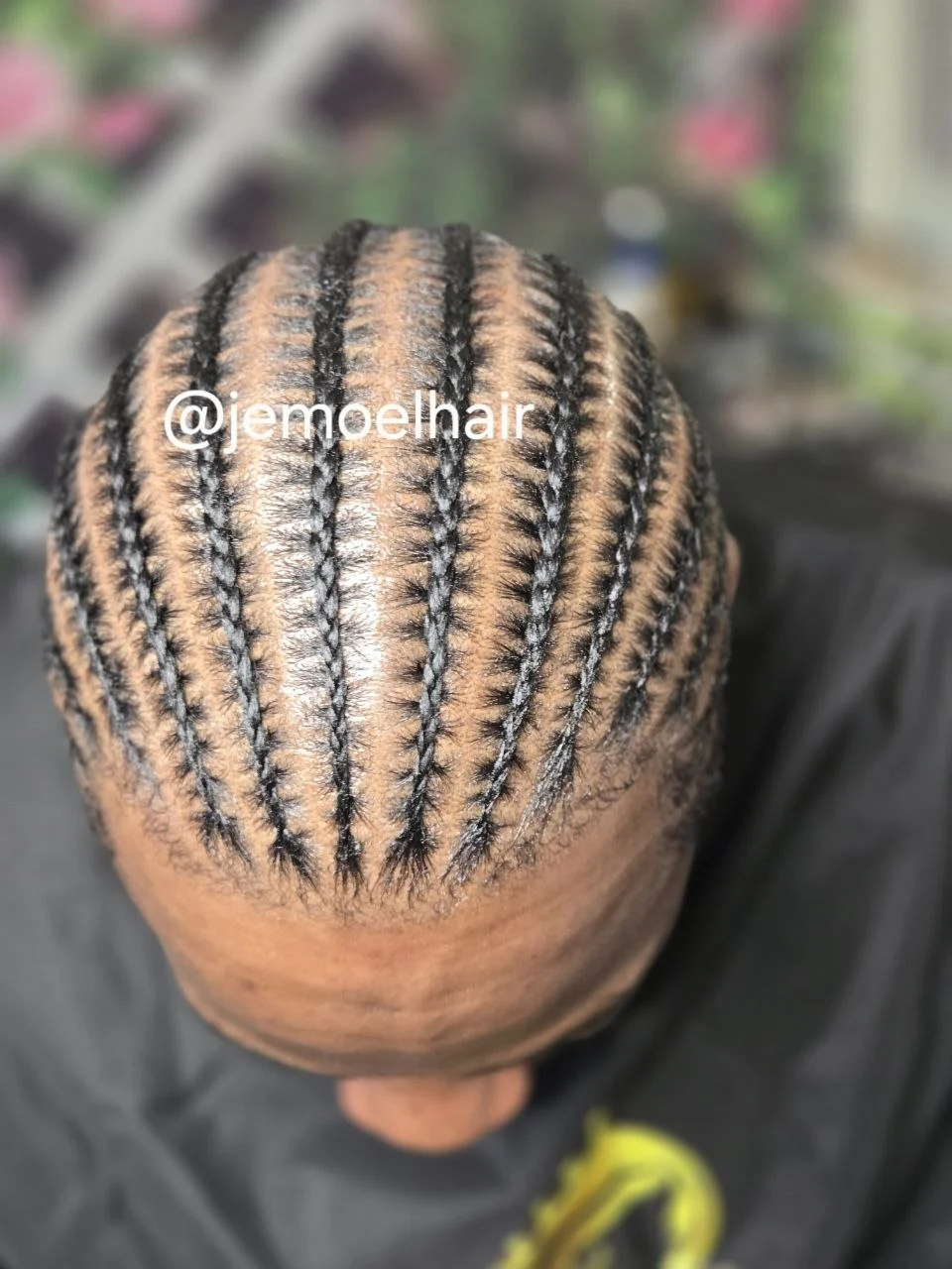 Top-down view of a man's head with neat straight-back stitch braid cornrows.