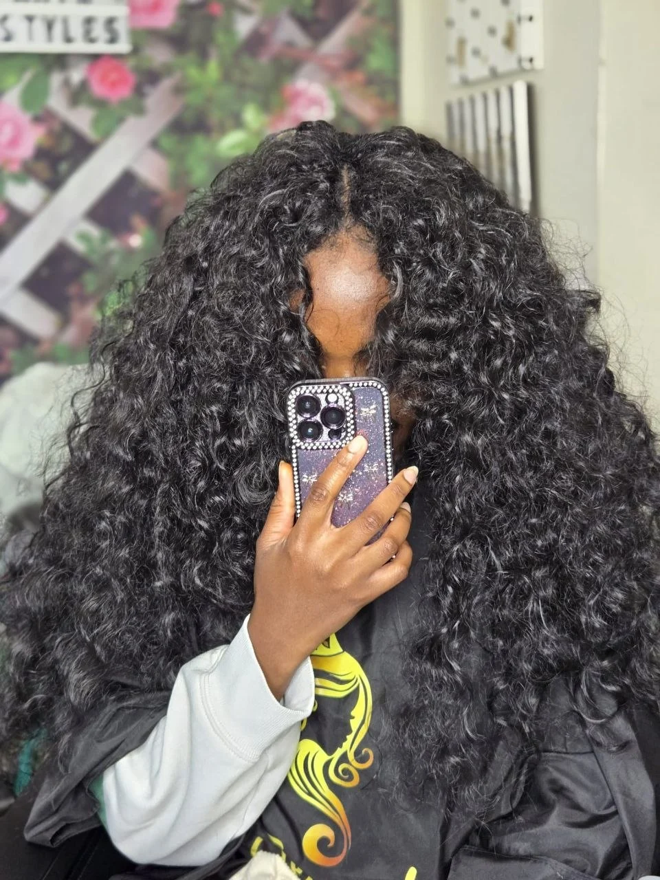 Long curly crochet hairstyle with a natural, seamless middle part.